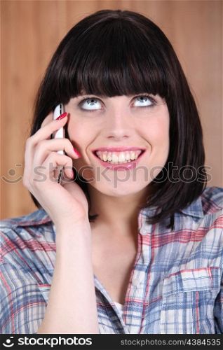 Woman with a broad grin talking on the phone