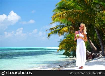 woman with a coconut cocktail on a tropical shore