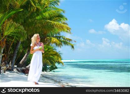 woman with a coconut cocktail on a tropical shore