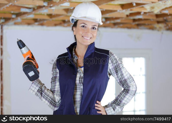 woman with a drill in protective clothes