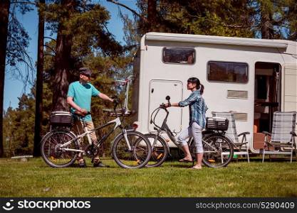 Woman with a man on electric bike resting at the campsite.. Woman with a man on electric bike resting at the campsite. Family vacation travel, holiday trip in motorhome RV, Caravan car Vacation.