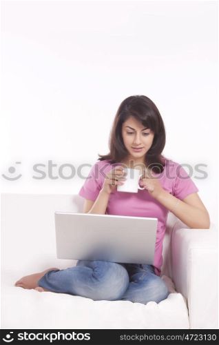 Woman with a mug of tea and laptop