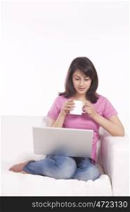 Woman with a mug of tea and laptop
