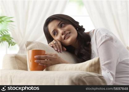 Woman with a mug of tea day dreaming
