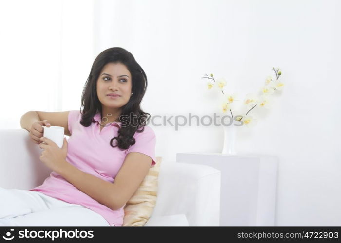 Woman with a mug of tea thinking