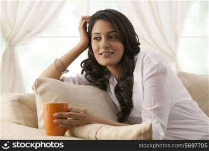 Woman with a mug of tea thinking