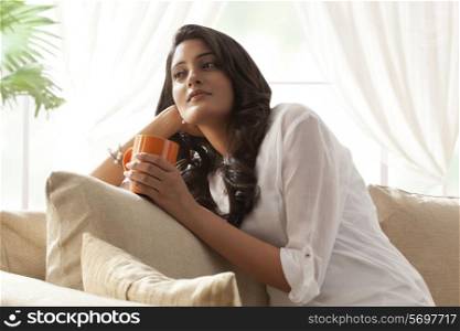 Woman with a mug of tea thinking