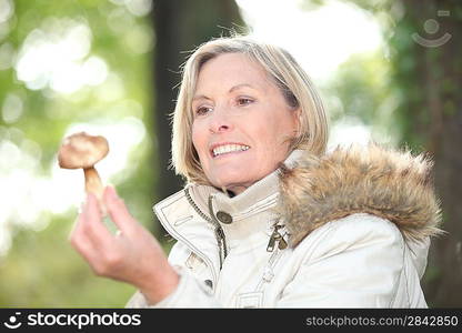 Woman with a mushroom in a forest