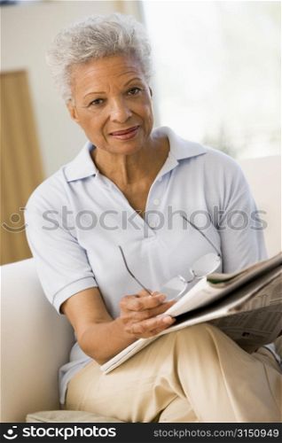 Woman with a newspaper holding eyeglasses