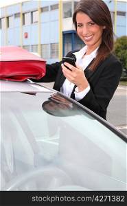 Woman with a phone by her car