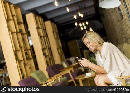 Woman with a phone sitting in a cafe