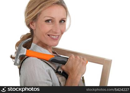 Woman with a picture frame and hammer.