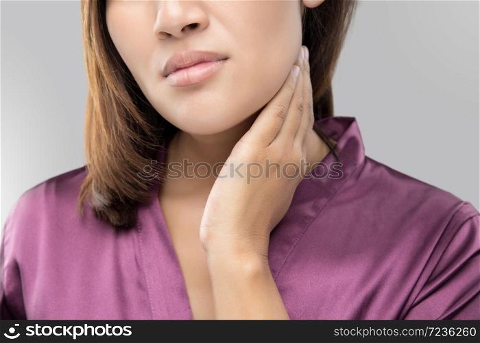 Woman with a sore throat holding her neck, On gray Background, Lymphadenopathy, People with health problem concept.