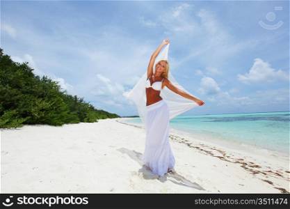 woman with a white cloth in his hands on the beach
