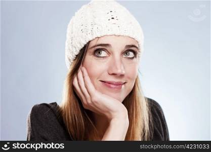 woman with a winter cap looking up. woman with a winter cap looking up on light blue background