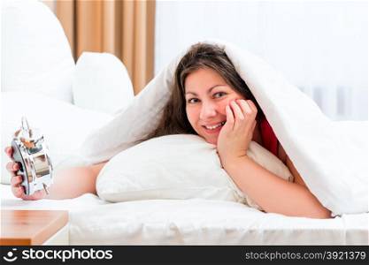 woman with an alarm clock and a good start of the day