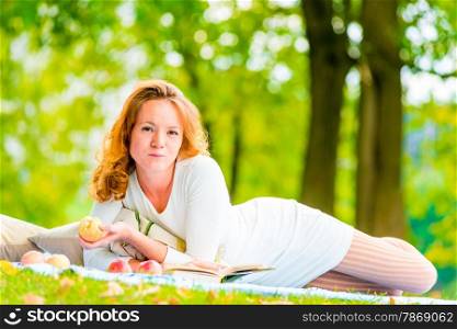 woman with an apple resting on the weekend in the park