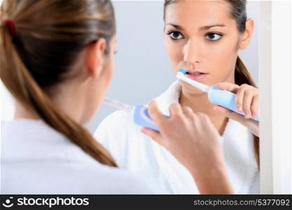 Woman with an electric toothbrush