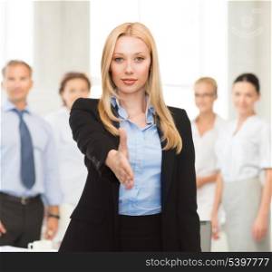 woman with an open hand ready for handshake in office
