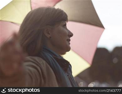 Woman with an umbrella in the rays of a sun. Shallow depth of field.