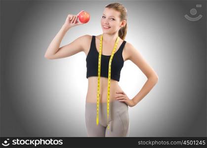 Woman with apple doing exercises on white