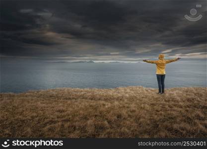 Woman with arms raised enjoying the nature in Iceland