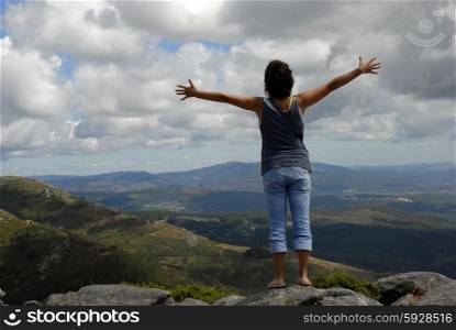 woman with arms wide open in the mountain
