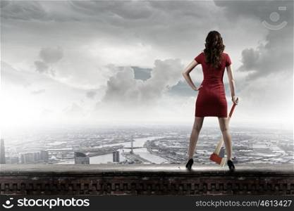 Woman with axe. Pretty woman in red dress with axe in hand
