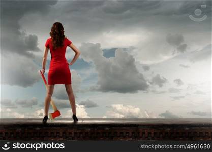 Woman with axe. Pretty woman in red dress with axe in hand