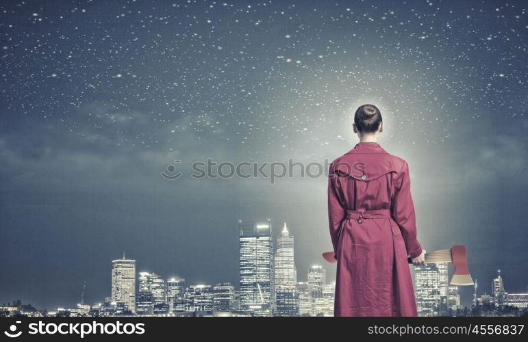 Woman with axe. Rear view of woman in red coat with axe in hands