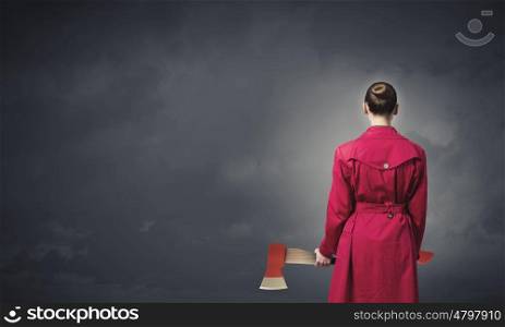 Woman with axe. Rear view of woman in red coat with axe in hands