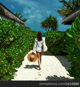 Woman with bag and sun hat going to the beach