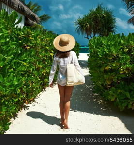 Woman with bag and sun hat going to the beach