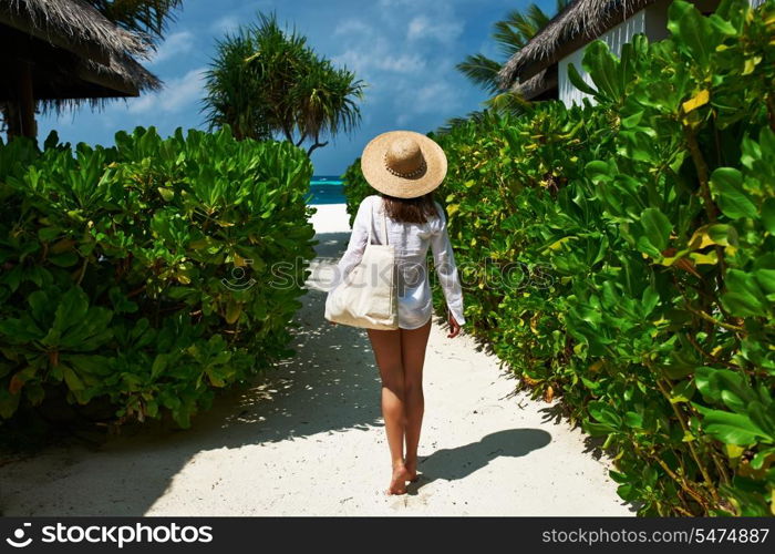 Woman with bag and sun hat going to the beach