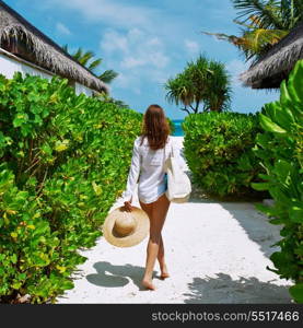 Woman with bag and sun hat going to the beach