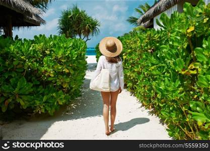 Woman with bag and sun hat going to the beach