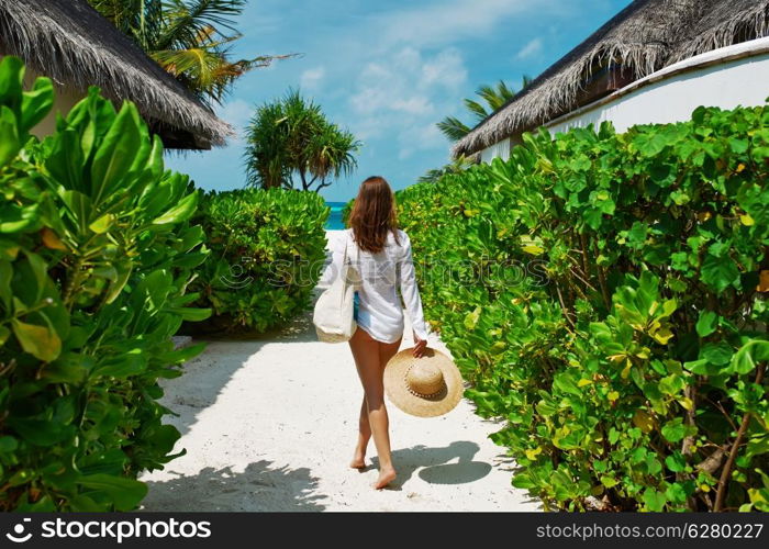 Woman with bag and sun hat going to the beach