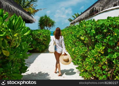 Woman with bag and sun hat going to the beach