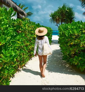 Woman with bag and sun hat going to the beach