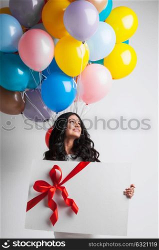 Woman with balloons and gift. Young smiling woman with balloons and big gift box