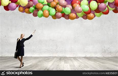Woman with balloons. Young businesswoman with suitcase and bunch of colorful balloons