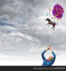 Woman with balloons. Young girl in casual with bunch of colorful balloons