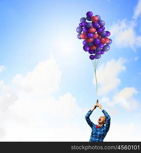 Woman with balloons. Young woman in casual holding bunch of colorful balloons