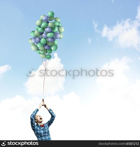 Woman with balloons. Young woman in casual holding bunch of colorful balloons