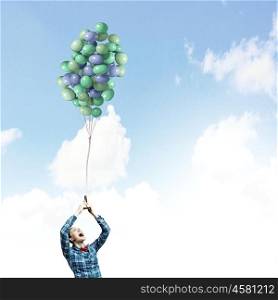 Woman with balloons. Young woman in casual holding bunch of colorful balloons