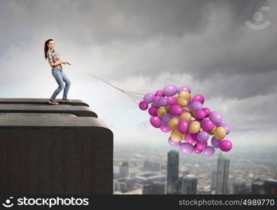 Woman with balloons. Young woman in casual holding bunch of colorful balloons