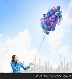 Woman with balloons. Young woman in casual holding bunch of colorful balloons