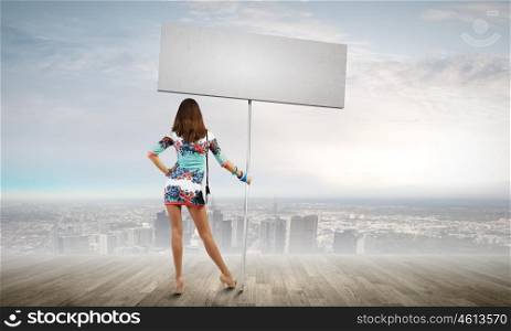 Woman with banner. Rear view of woman in short dress with blank banner