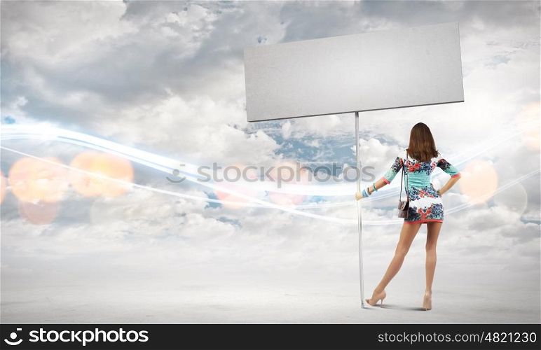 Woman with banner. Rear view of woman in short dress with blank banner