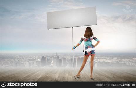 Woman with banner. Rear view of young attractive woman with blank white banner